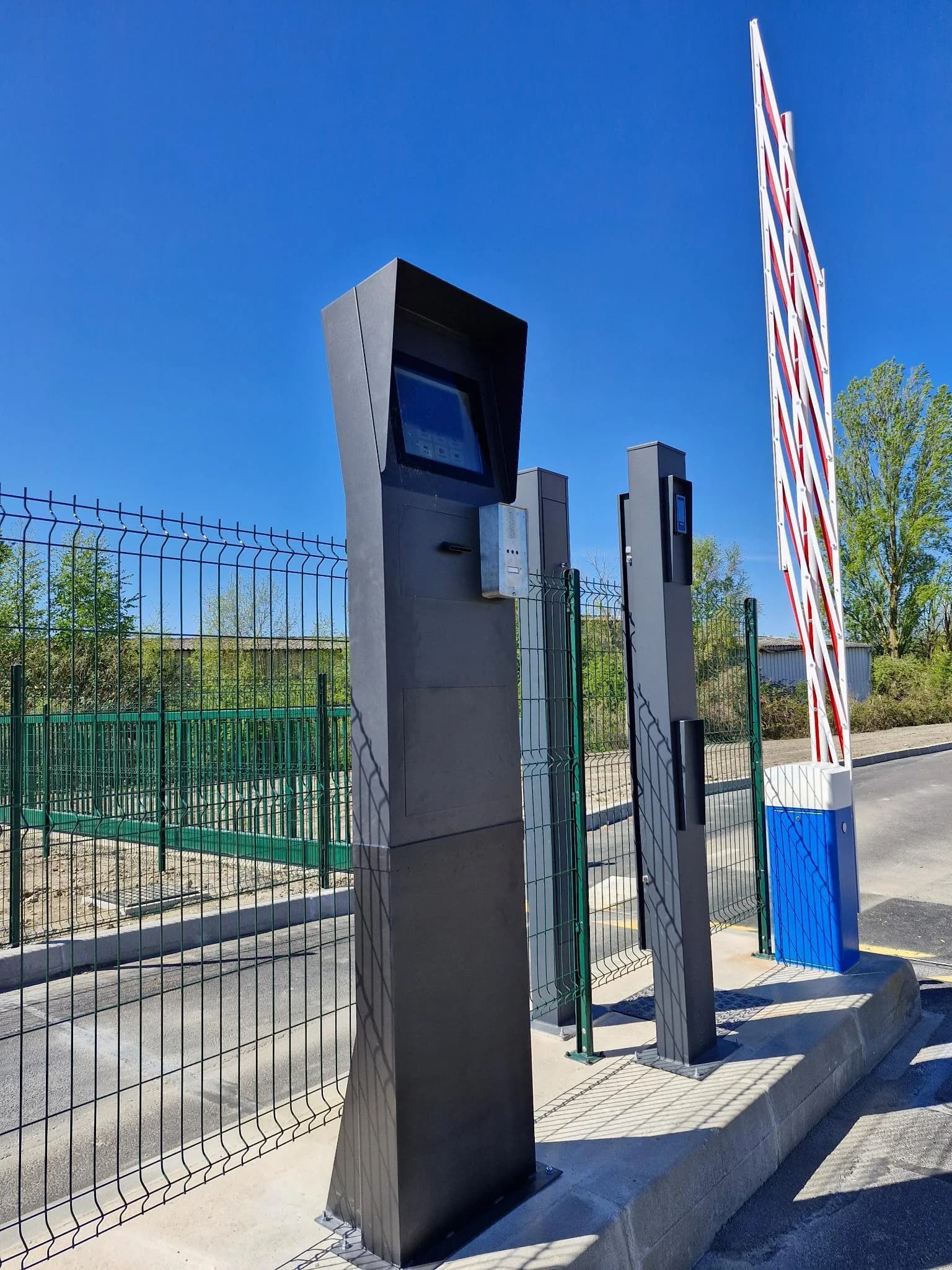 Borne de contrôle d'accès installée sur site avec barrière levante